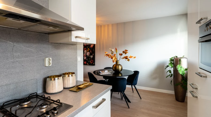 Een keuken met een fornuis en een eettafel. meubels huren, meubelverhuur luxe pakket